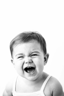 A black and white photo of a baby screaming.