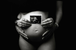 An image of a pregnant woman holding an ultrasound.